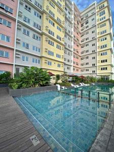 a large swimming pool in front of a building at Voice activated studio condo unit at One Regis Megaworld, JK Modern Nest in Bacolod