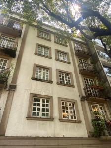 a tall white building with windows and balconies at Habitación Privada en La Colonia Roma in Mexico City