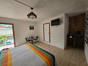 a bedroom with a bed and a table with a television at Hotel Colonial Campestre in UniÃ³n JuÃ¡rez
