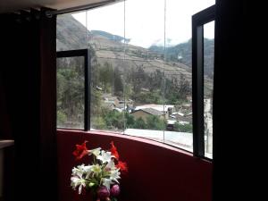 een raam met een bos bloemen ervoor bij Hostal El Viajero in Surcubamba