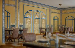 a dining room with tables and chairs and yellow walls at Storii By ITC Hotels, Jaisalmer in Jaisalmer