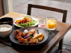 a table with a plate of food and a bowl of rice at Daiwa Roynet Hotel Sapporo-Susukino in Sapporo