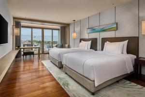 Voodi või voodid majutusasutuse Shenzhen Dameisha Kingkey Palace Hotel toas