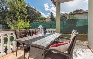 a table and chairs on a porch with a fence at Lovely Apartment In Pavicini With Wifi in Pavicini