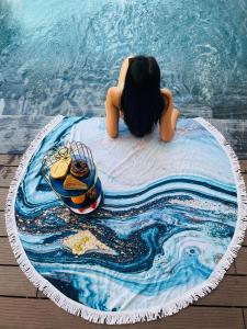 Seascape Villas In Long Beach Cam Ranh في كام رنه: فتاة تجلس على مرتبة حمام السباحة في الماء