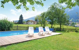 eine Gruppe von drei Liegestühlen neben einem Pool in der Unterkunft Ferienhaus - Westendorf in Westendorf