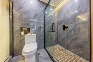 a bathroom with a toilet and a glass shower at 天门山云尚景豪酒店 in Zhangjiajie