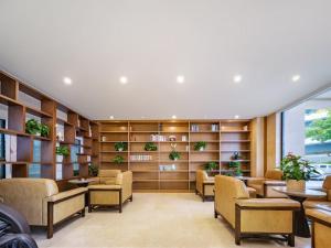 a waiting room with chairs and bookshelves at 天门山云尚景豪酒店 in Zhangjiajie
