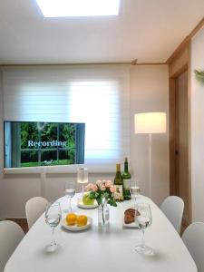 a white table with wine glasses and fruit and flowers at Yun Stay Seongsu in Seoul
