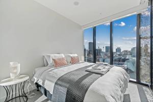 a bedroom with a bed and a large window at One bedroom apartment in the heart of CBD in Adelaide
