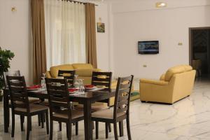 a dining room with a table and chairs and a couch at The Voice Hotel in Entebbe