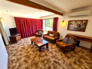 a living room with a couch and chairs and a table at Bridge Motel Wellington in Wellington