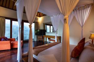 a bedroom with a bed with white drapes at Enchanting Canggu Villa in Tumbak Bayuh