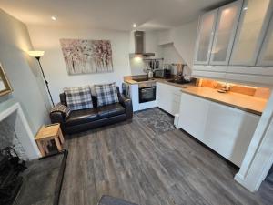a kitchen with a couch and a chair in a room at Pannanich View Cottage, Ballater in Ballater