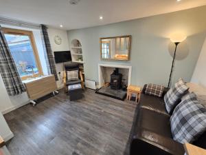 a living room with a couch and a fireplace at Pannanich View Cottage, Ballater in Ballater