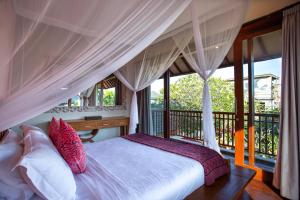 a bedroom with a bed and a balcony with windows at Enchanting Canggu Villa in Tumbak Bayuh +41 photos