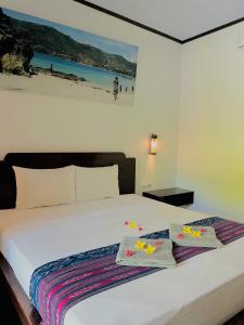 a bedroom with a bed with two towels on it at Edelweiss Homestay in Kuta Lombok