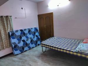 a room with a couch and a bed in it at Honeycomb Homestay Ground Floor in Palani