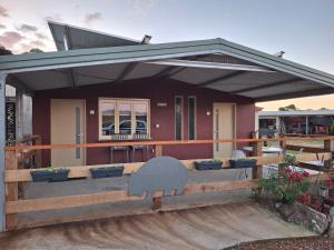 una casa con una gran terraza con un edificio en L'Air du Wombat Truffle Farm, en Corang