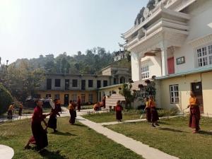a group of people standing in the grass in front of a building at Home Stay Nunnery in Burhānilkantha