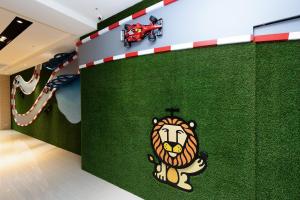 Holiday Garden Hotel SKM Park في كاوشيونغ: غرفة ذات جدار أخضر عليه أسد