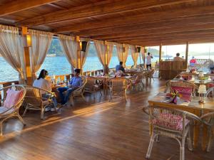 a group of people sitting at tables in a restaurant at Phonethavy GUESTHOUSE in Luang Prabang