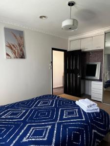 威勒比3 BR villa in Werribee near to Werribee CBD的一间卧室，床上铺着一条蓝色的毯子