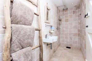 y baño con lavamanos y toallero. en Castaways, Cottage With Sea Views, Lush Gardens & Patio By the Beach, en Sennen