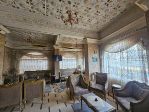 a living room with chairs and a ceiling with a chandelier at Rasheed International Hotel - Families Only in Rashīd
