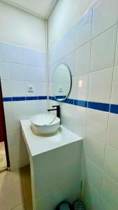 une salle de bain avec un lavabo et un miroir dans l'établissement Ellenbrook Rooms 18 by Mulia Cottage, à Seminyak