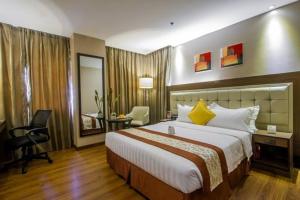 a hotel room with a large bed and a desk at ACE Hotel and Suites in Manila +23 photos