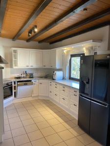 a kitchen with white cabinets and a black refrigerator at Westerwaldhaus in Gieleroth