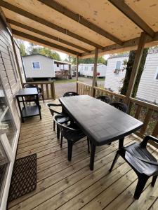 a wooden deck with a table and chairs on it at Nature océan mobil-home in Capbreton