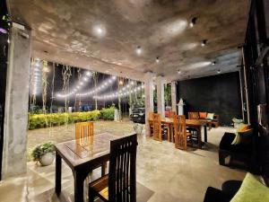 a dining room with a table and chairs and lights at Catch Up Dambulla in Dambulla