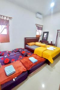 two beds sitting next to each other in a bedroom at Omah Tabon Homestay Heritage Stay near Malioboro in Yogyakarta