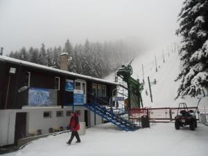 una persona caminando por la nieve cerca de un remonte en Pension Mikulka, en Mikulov v Krušných Horách