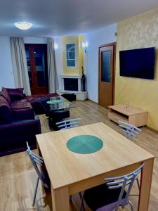 ein Wohnzimmer mit Tisch und Couch in der Unterkunft PAMPOROVO Raikovski lodge in Pamporowo