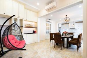 a kitchen and dining room with a swing chair in a room at KN 2 Villa - Venuestay in Ho Chi Minh City