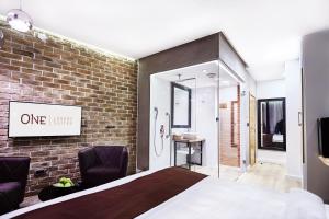 a bedroom with a bed and a brick wall at One Luxury Suites in Belgrade