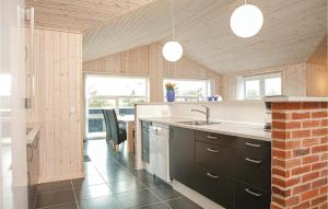 a kitchen with a sink and a brick wall at Holiday Home Astavej Løkken in Løkken
