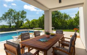 a patio with a wooden table and chairs and a pool at Villa Lucas in Pula