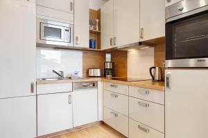 a kitchen with white cabinets and stainless steel appliances at Haus A Cappella B6 in Binz