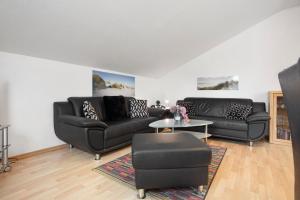 a living room with two black couches and a table at Haus A Cappella B6 in Binz