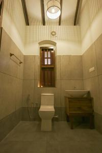 a bathroom with a toilet and a sink at Kowdi House - A Heritage Homestay in Cochin +13 photos