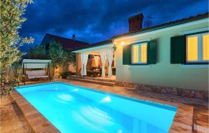 a swimming pool in front of a house at night at Villa Valencan in Rovinj