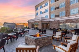 a patio with a fire pit in front of a building at Cambria Hotel Manchester South Windsor in South Windsor