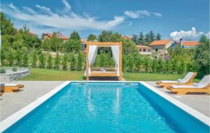 a swimming pool with a gazebo next to a house at Villa Ena Mar in Zadar