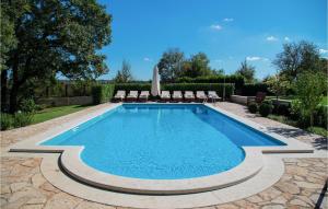 a swimming pool in a yard with chairs around it at Villa Kringa in Kučići