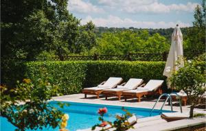 a swimming pool with lounge chairs and an umbrella at Villa Kringa in Kučići