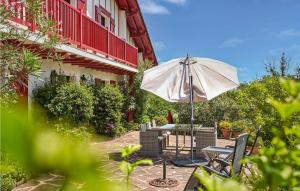 a patio with an umbrella and a table and chairs at Amazing Apartment In Saint Jean De Luz in Costa Aldia +5 photos